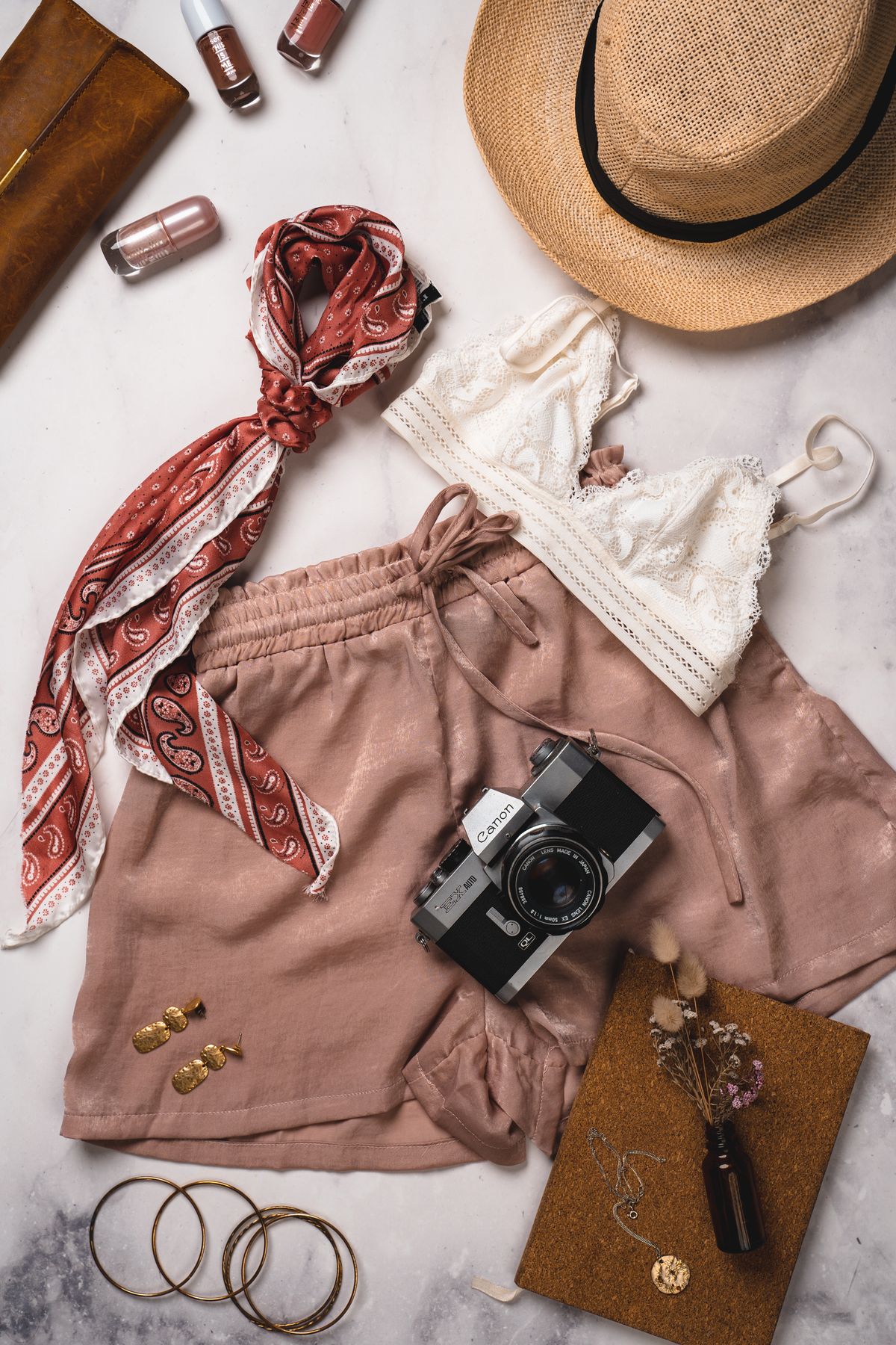 Reduziertes Flatlay mit Kleidung und Accessoires in warmen Naturtönen